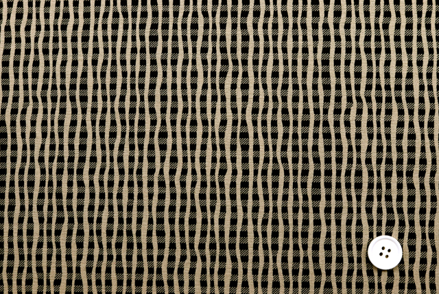 ベージュ地のよろけ格子柄ストレッチニット生地全体