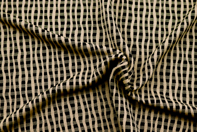 ベージュ地のよろけ格子柄ストレッチニット生地のドレープ