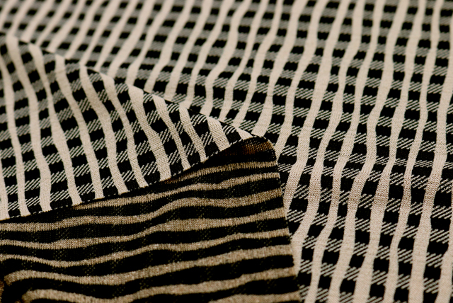 ベージュ地のよろけ格子柄ストレッチニット生地の裏面